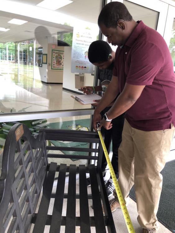 Cedrick White with a student measuring a bench outside McAdams Hall
