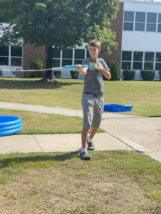 student shooting water from squirt gun