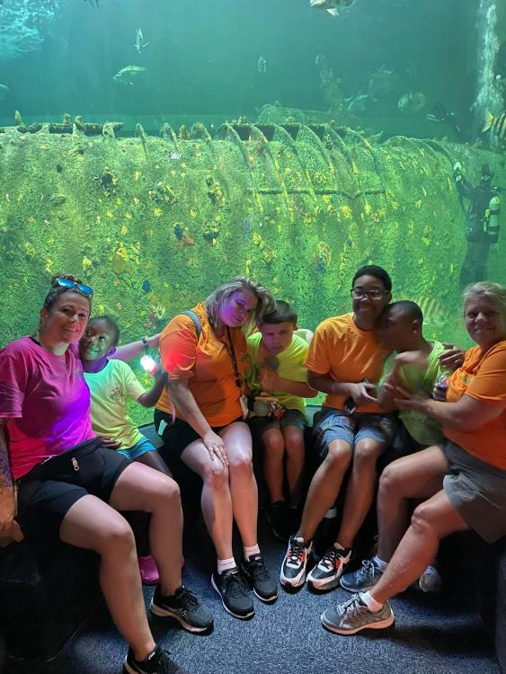 Students and staff sitting in front of an aquarium