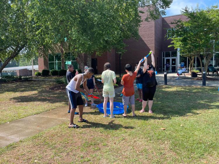soaked students loading squirt guns
