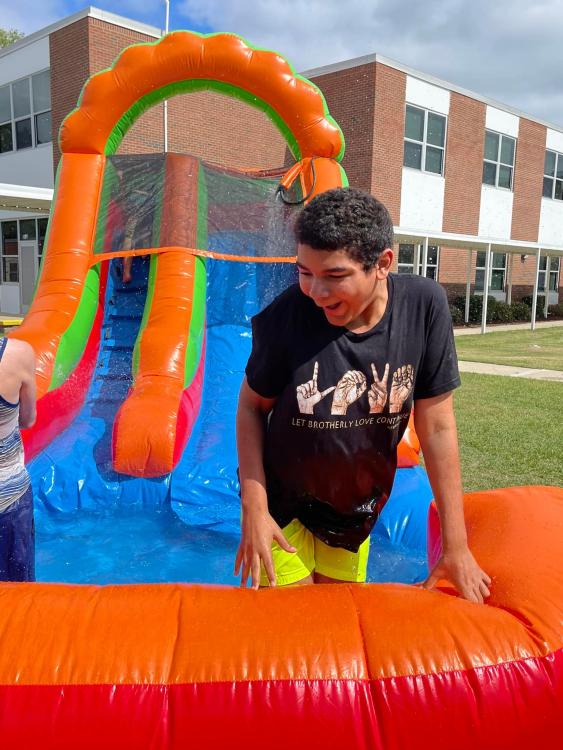 student on inflated water slide