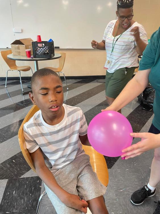 student playing with a balloon