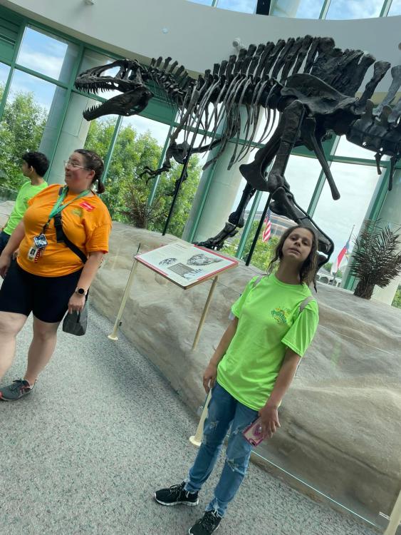 Student at the NC Museum of Natural Sciences with dinosaur skeleton display