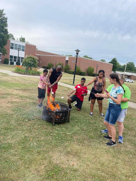 Students roasting marshmallows over firepit