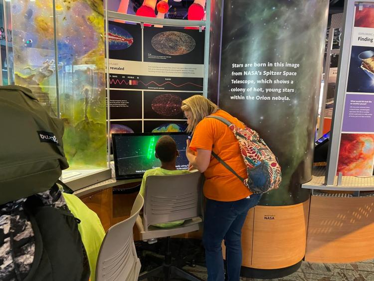 Jessica and a student looking at space images from Nasa's Spitzer telescope