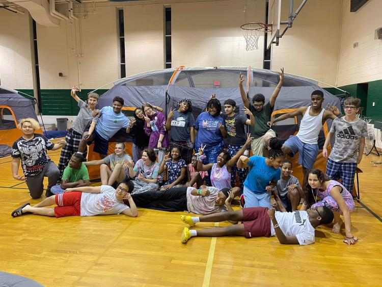 Crowd of students posing in front of a tent in the gym