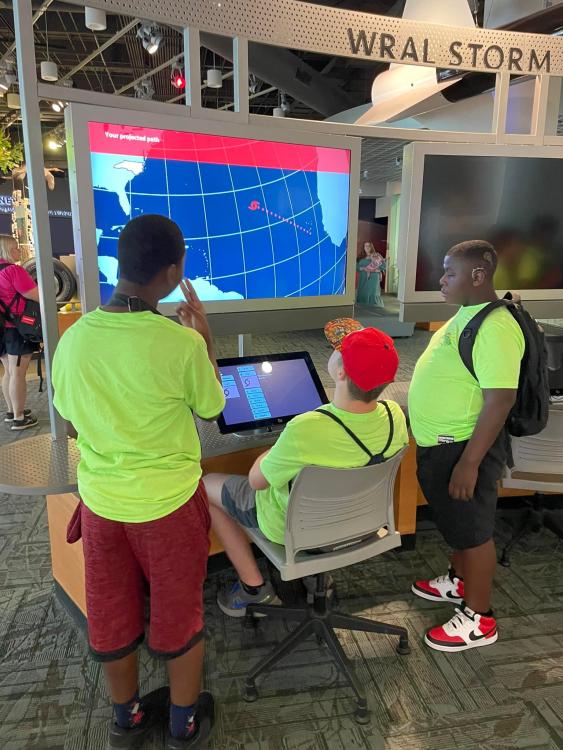 Student at the NC Museum of Natural Sciences looking at a weather exhibit