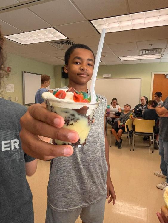 Student holding out his 'dirt' dessert cup