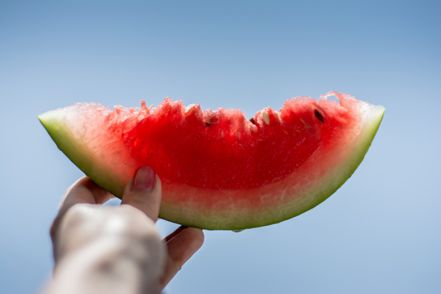 hand holding a slice of watermelon