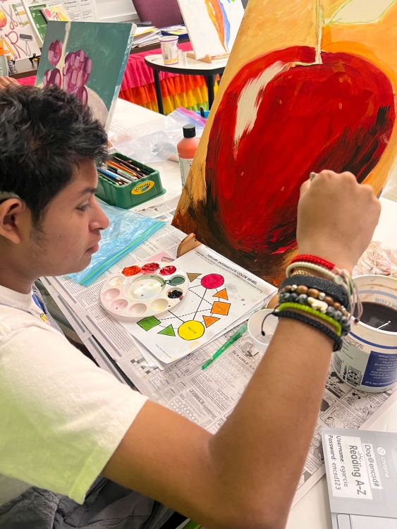 students painting an apple