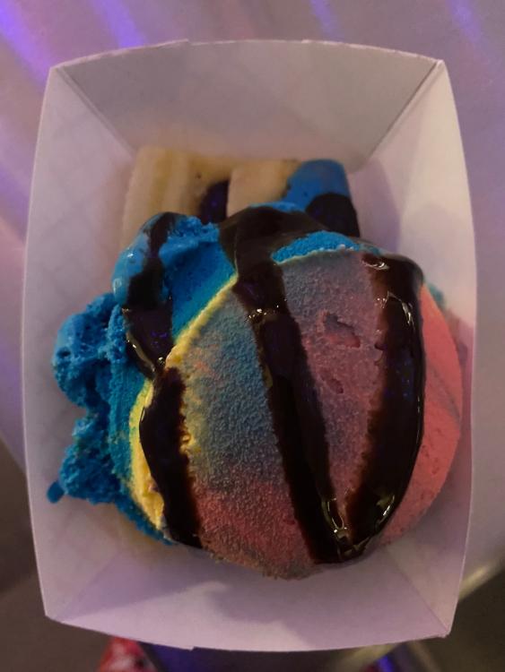Rainbow ice cream scoop  with chocolate syrup stripes