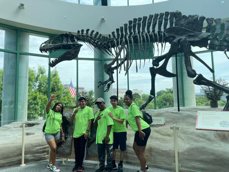 Students in front of dinosaur skeleton display