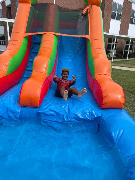 student on inflated water slide