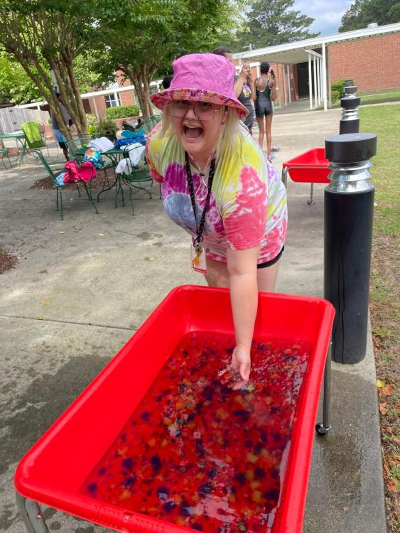 Natasha with hand in tub of colorful gelatin